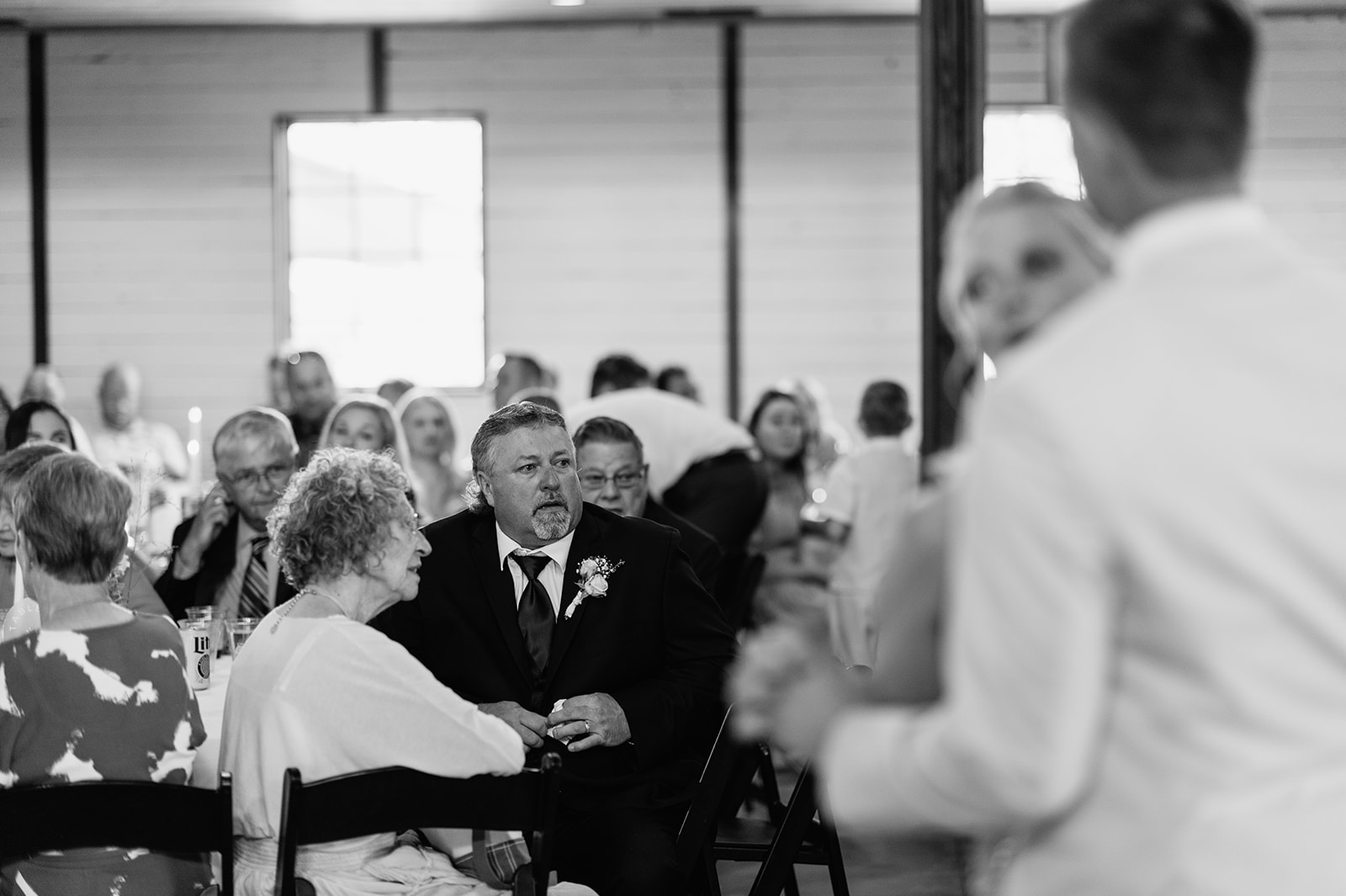 Black and white photo of a guests getting emotional as the groom dances with his mother