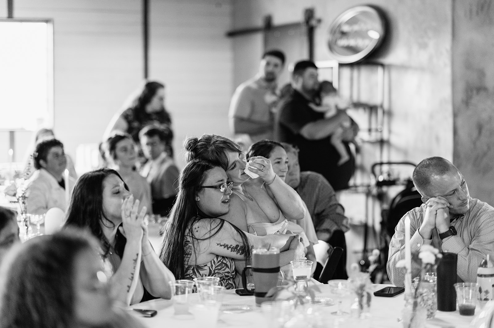 Black and white photo of guests getting emotional during a slideshow