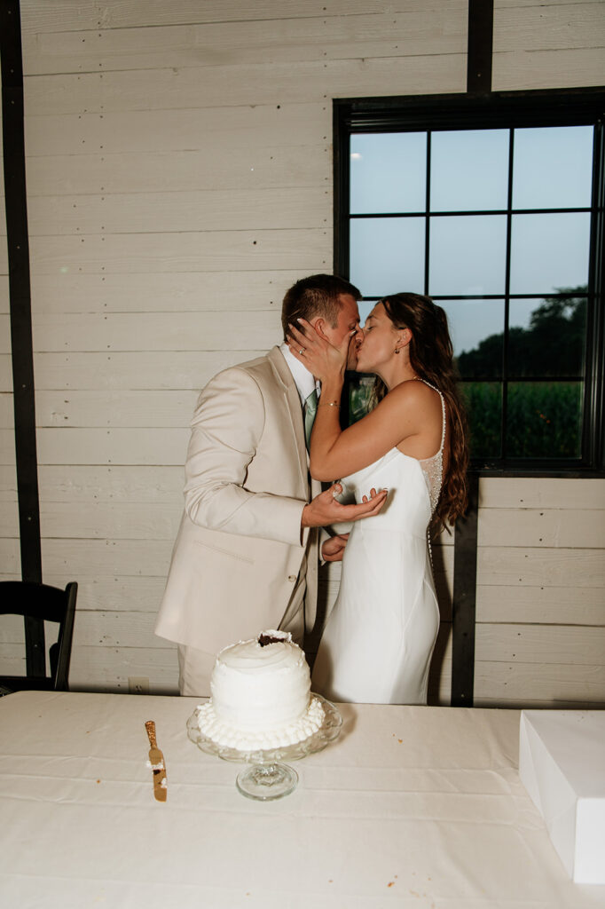 Brid and groom kissing during cake cutting