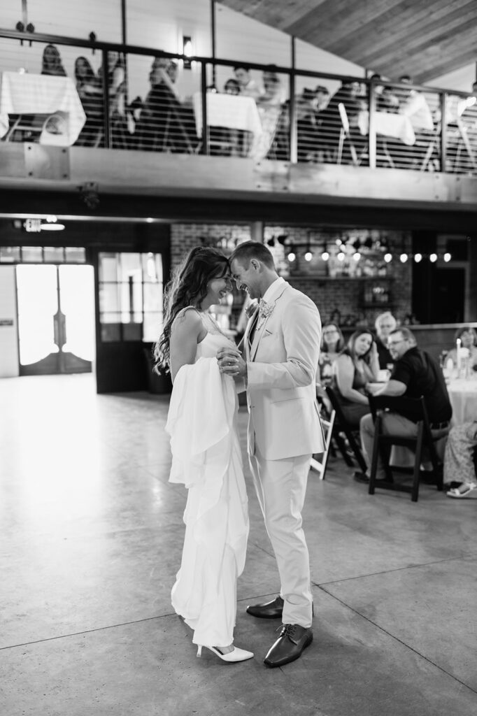 Black and white photo of a bride and groom sharing their first dance