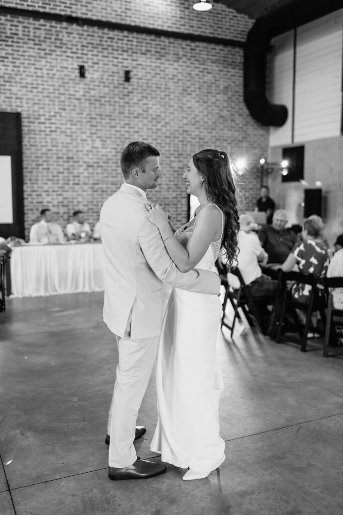 Black and white photo of a bride and groom sharing their first dance