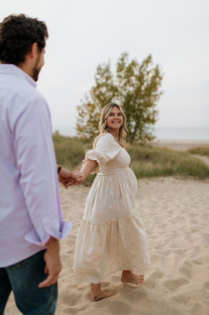 Man and woman walking along the beach and holding hands