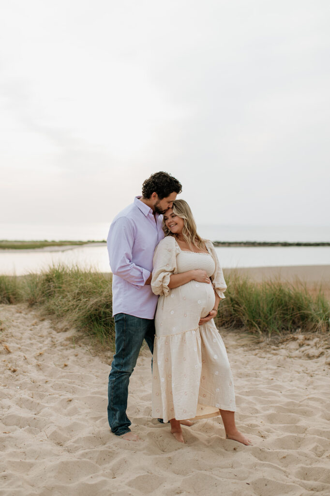 Couple posing on New Buffalo Beach for their Michigan maternity photos