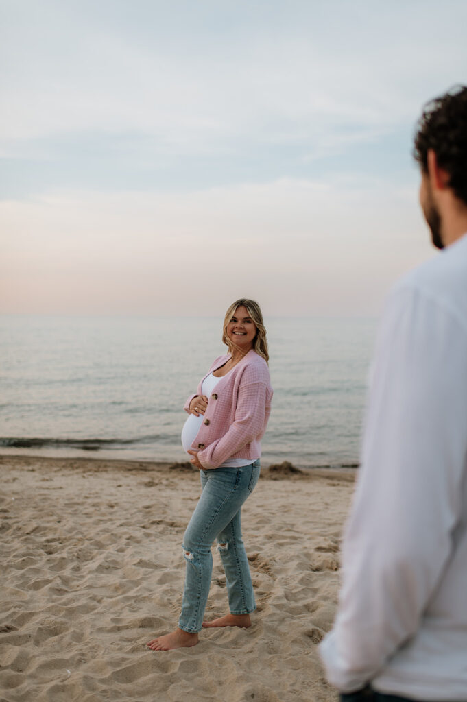 Man admiring his pregnant wife during their New Buffalo Beach maternity photos in Michigan