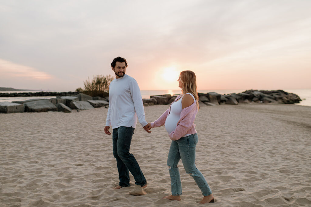 Man and woman walking the beach during sunset