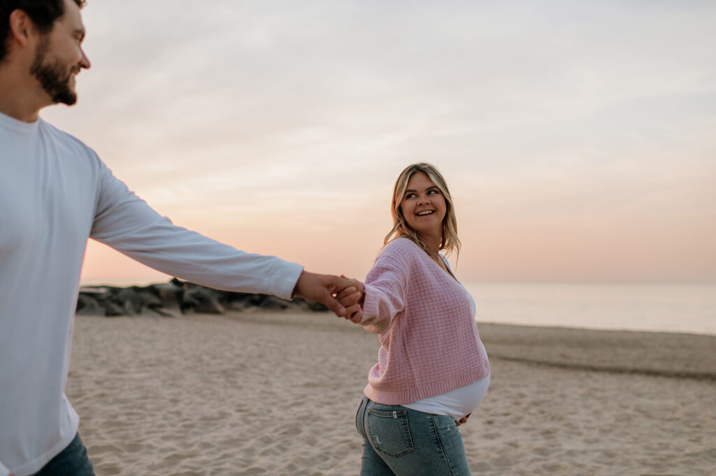 Man and woman walking the beach during sunset