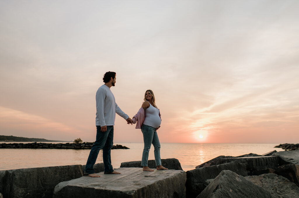 Couple walking along the beach rocks at New Buffalo Michigan