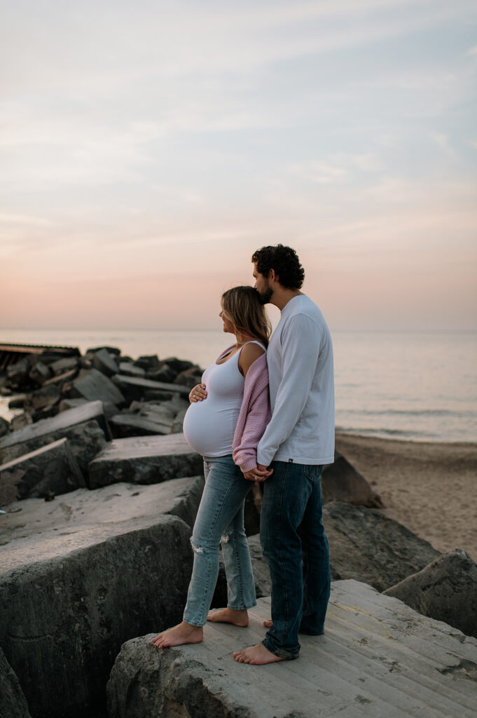 Couple admiring Lake Michigan during their beach maternity session