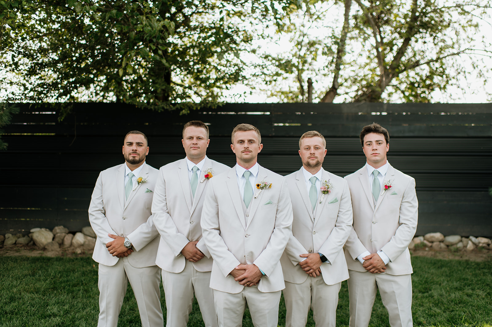 Grooms and groomsmens outdoor portraits during a summer Empeiria 110 wedding in Rochester, Indiana