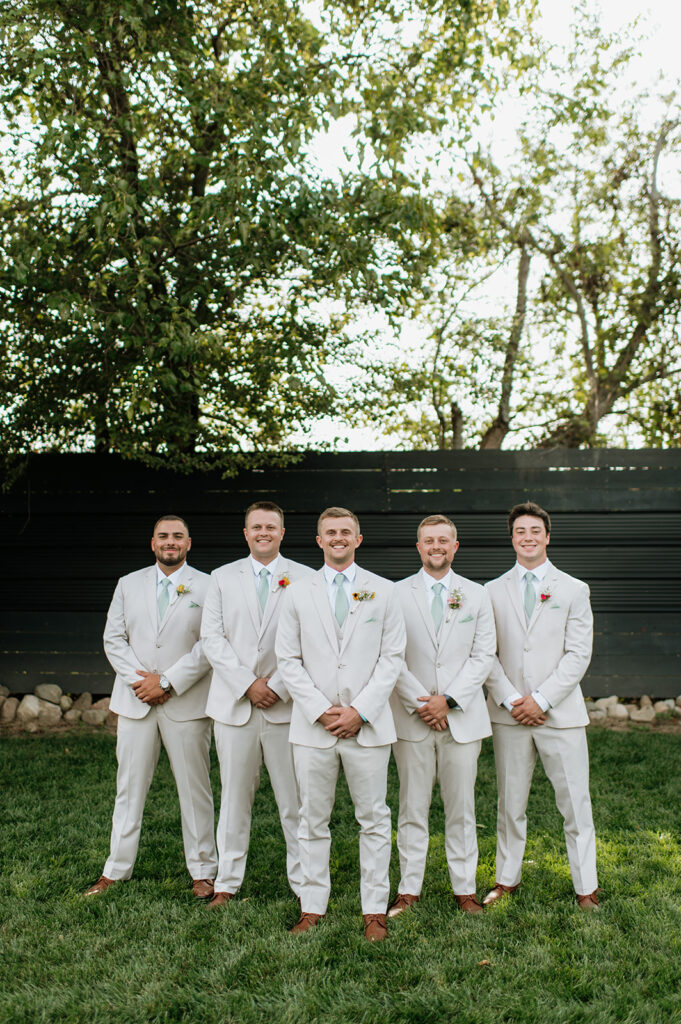 Grooms and groomsmens outdoor portraits during a summer Empeiria 110 wedding in Rochester, Indiana