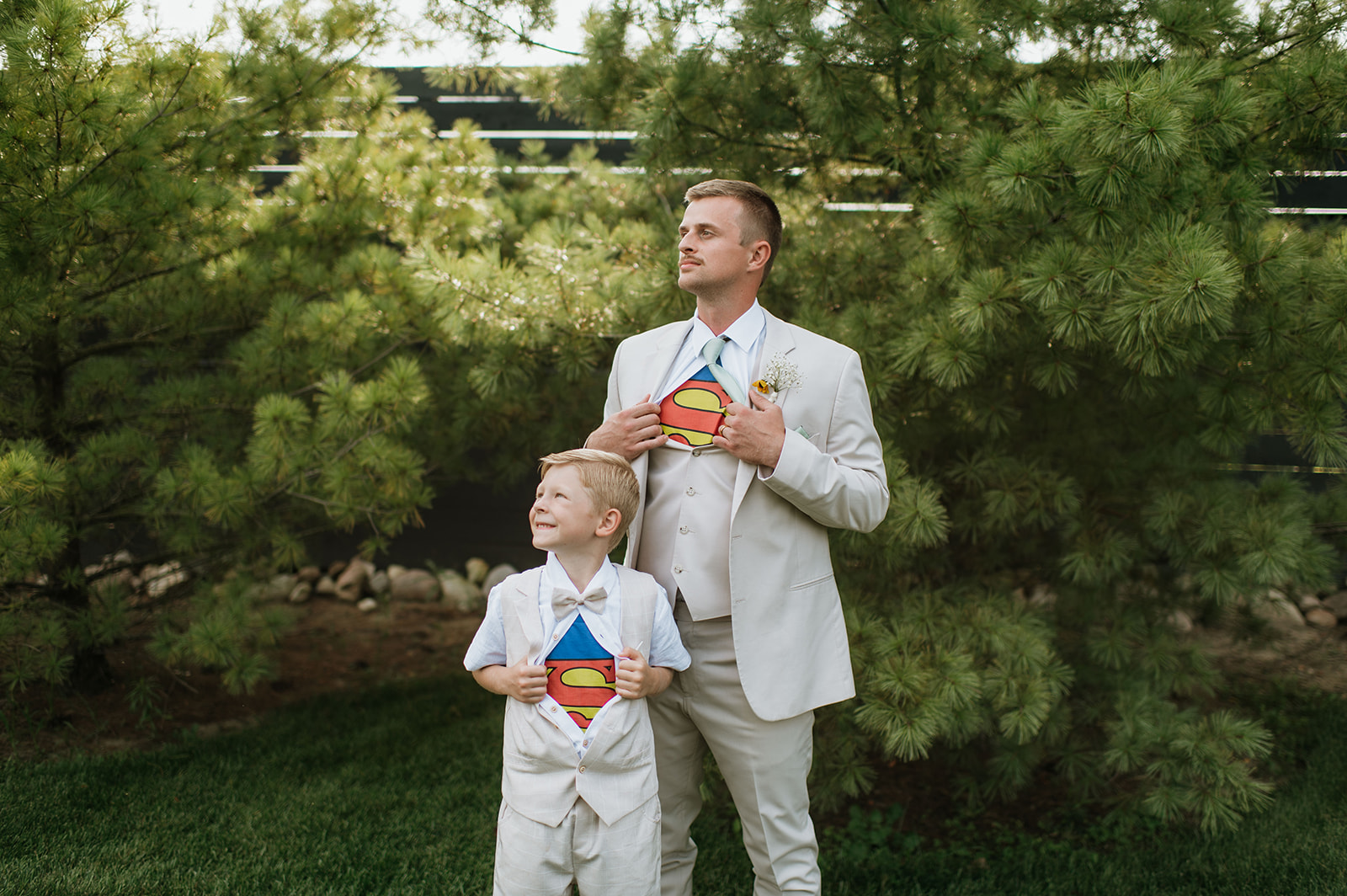 Groom and ring boy wearing superman shirts underneath their suits