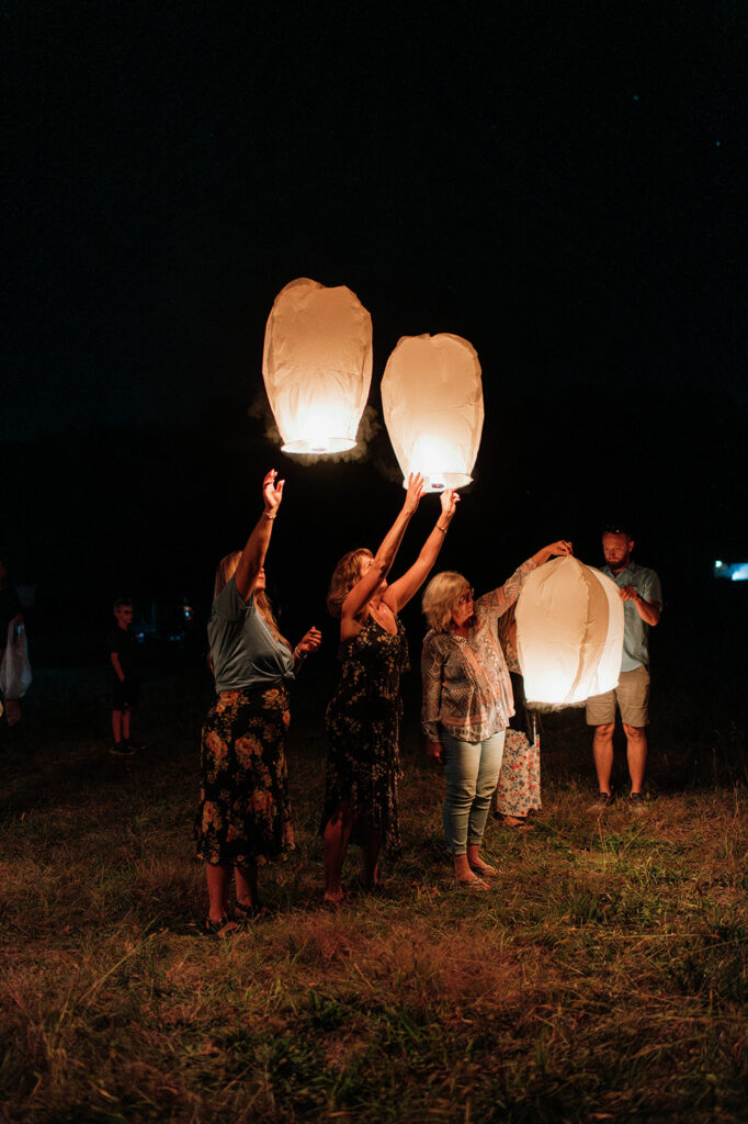 Wedding guests releasing lanterns in honor of the grooms late mother