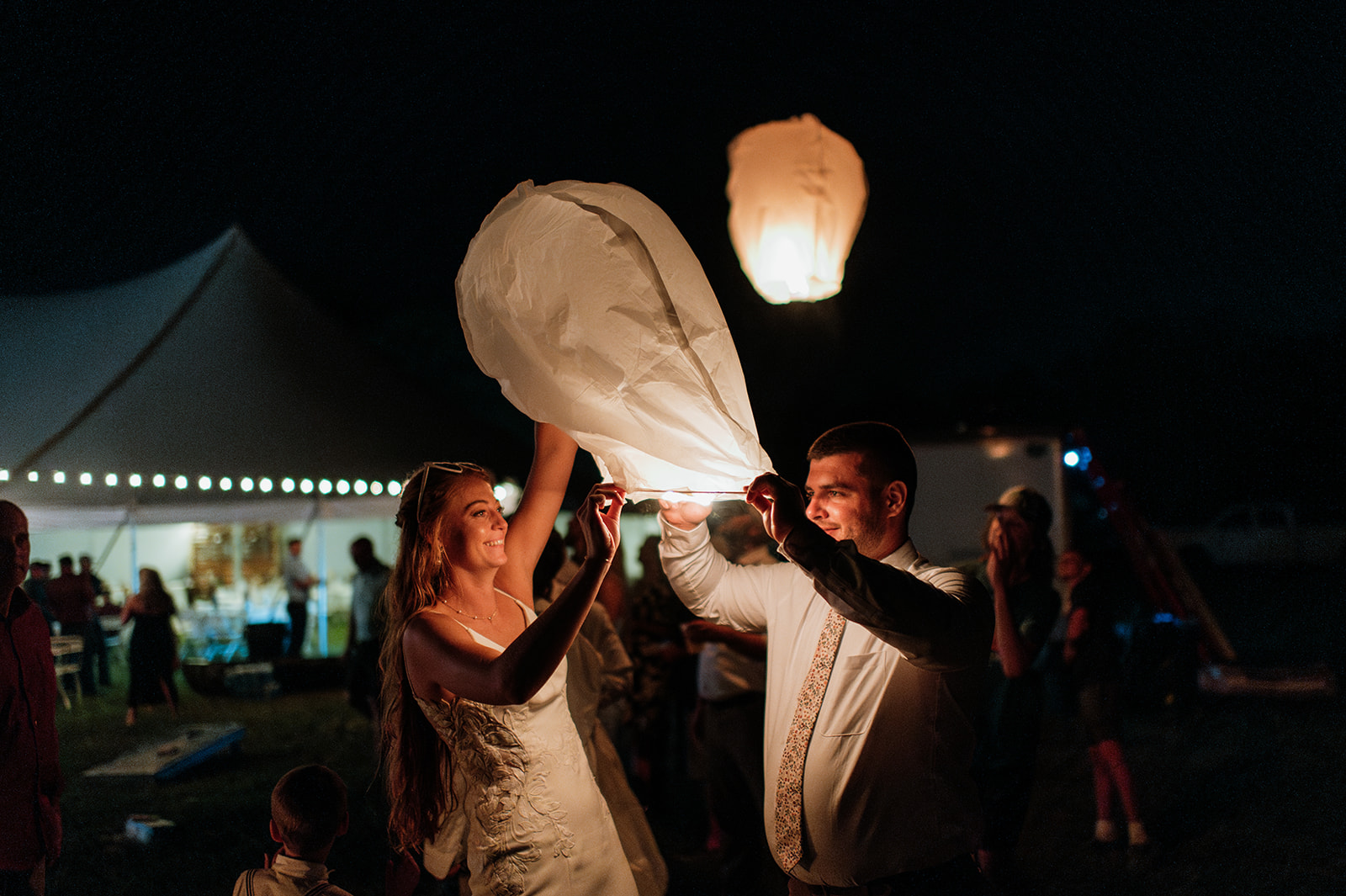 Bride and groom releasing lanterns in honor of the grooms late mother