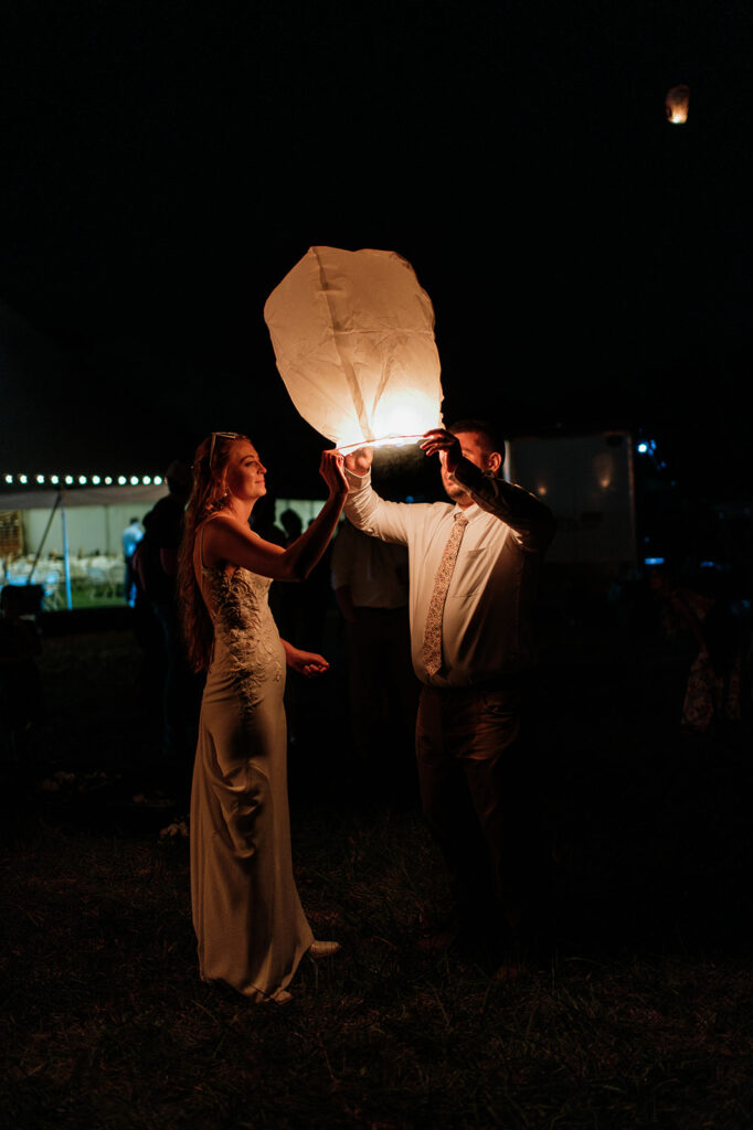 Bride and groom releasing lanterns in honor of the grooms late mother