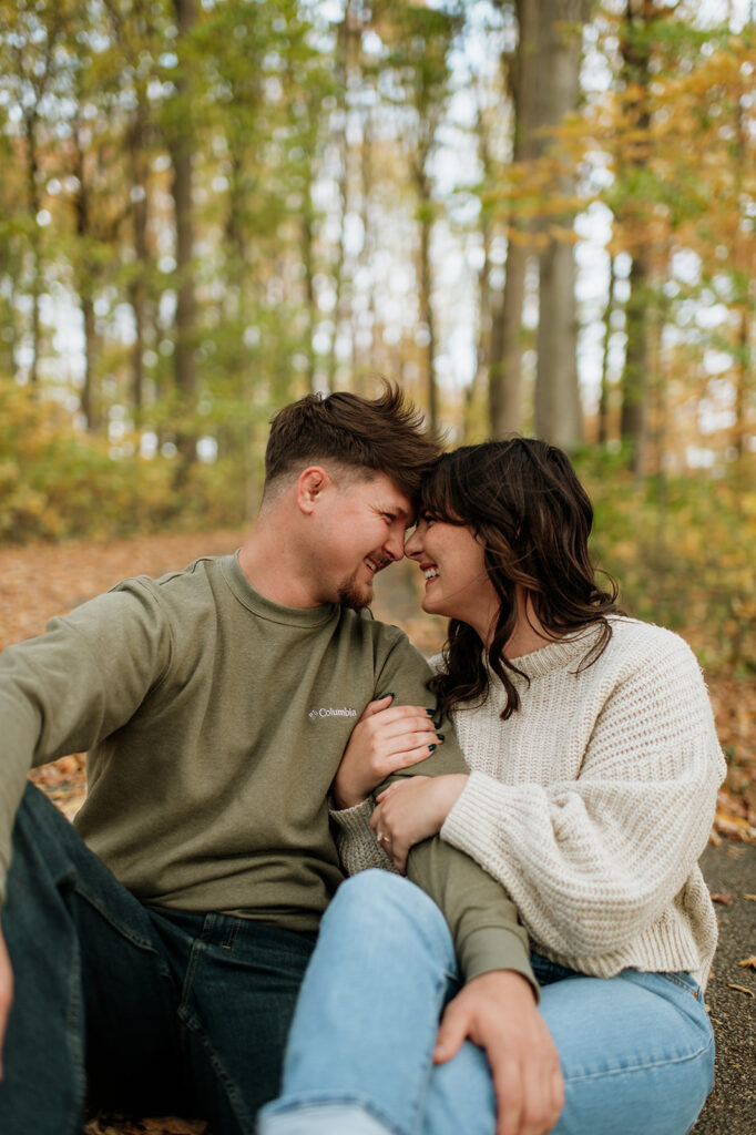 Couple sitting together during their fall engagement session in Potato Creek State Park