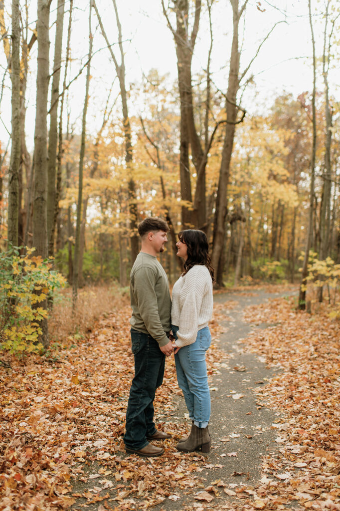 Couple holding hands during their fall engagement session