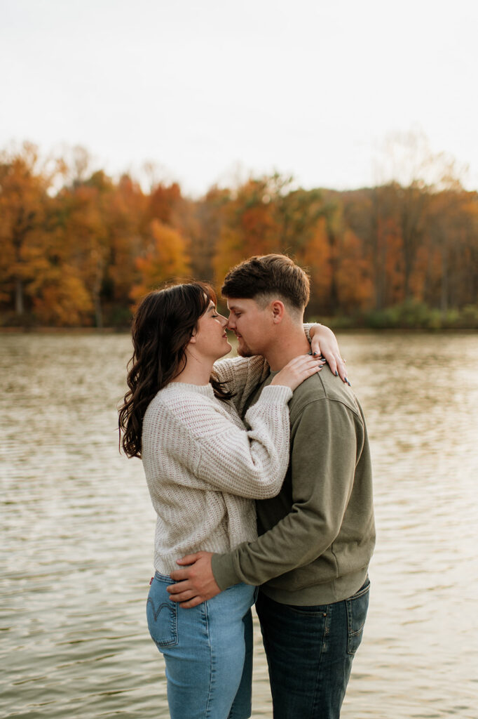 Couple touching noses during their fall engagement photos by Worster Lake