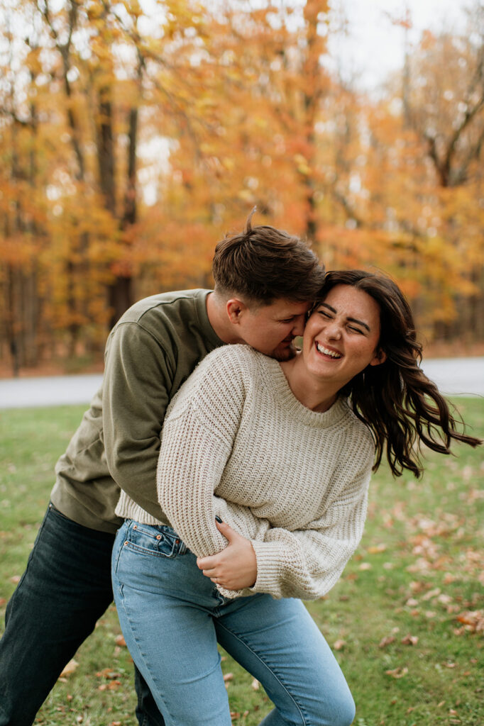 Candid engagement photo of a couple being playful during their fall engagement shoot