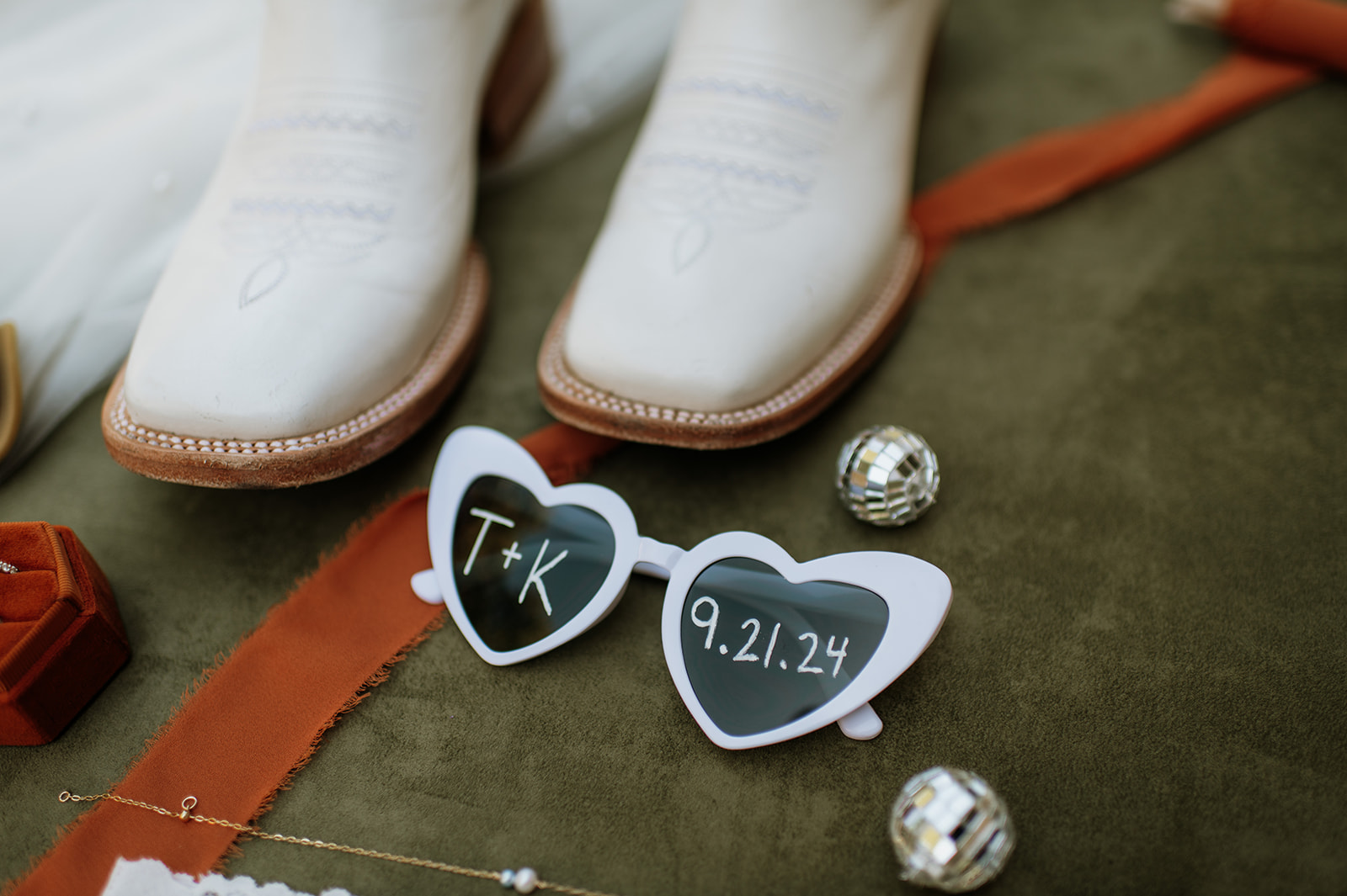 Wedding detail shot with disco balls, boots, and heart-shaped sunglasses