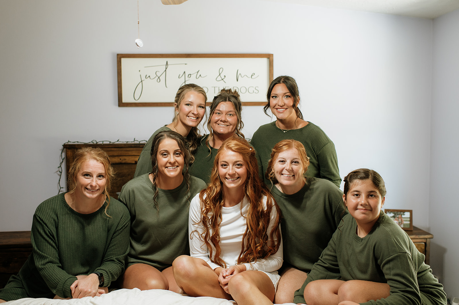 Bride and bridesmaids posing on a bed in pajamas