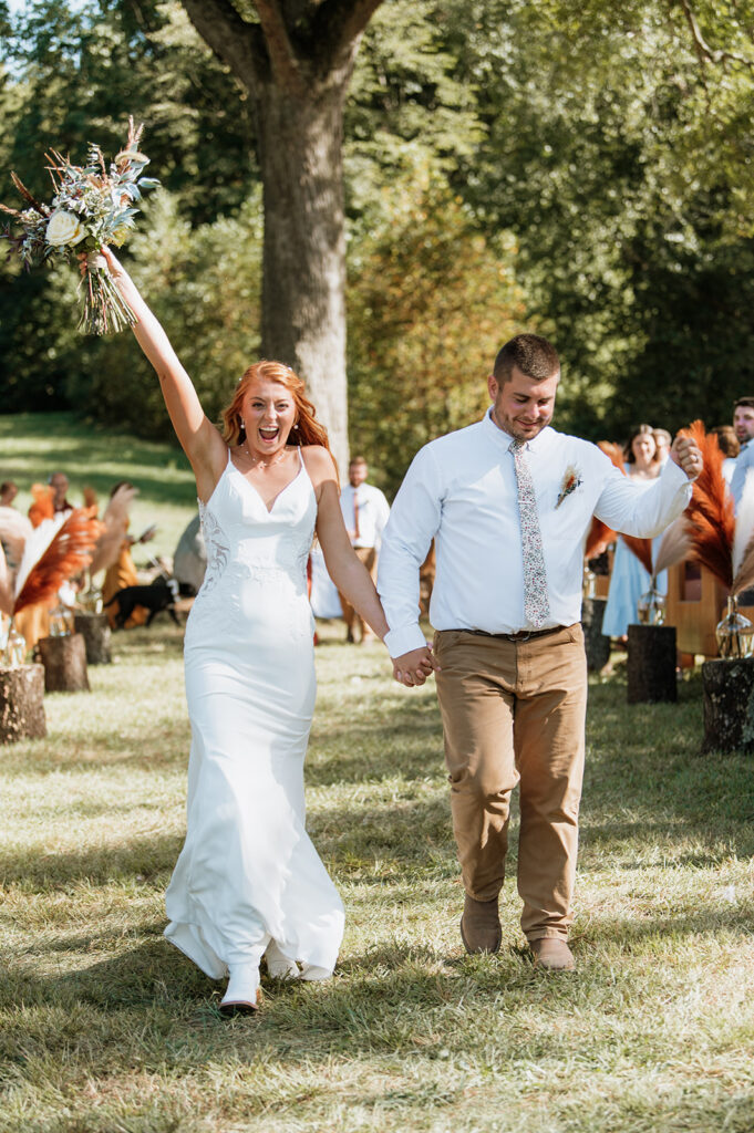 Bride and groom celebrating after their fall backyard wedding ceremony