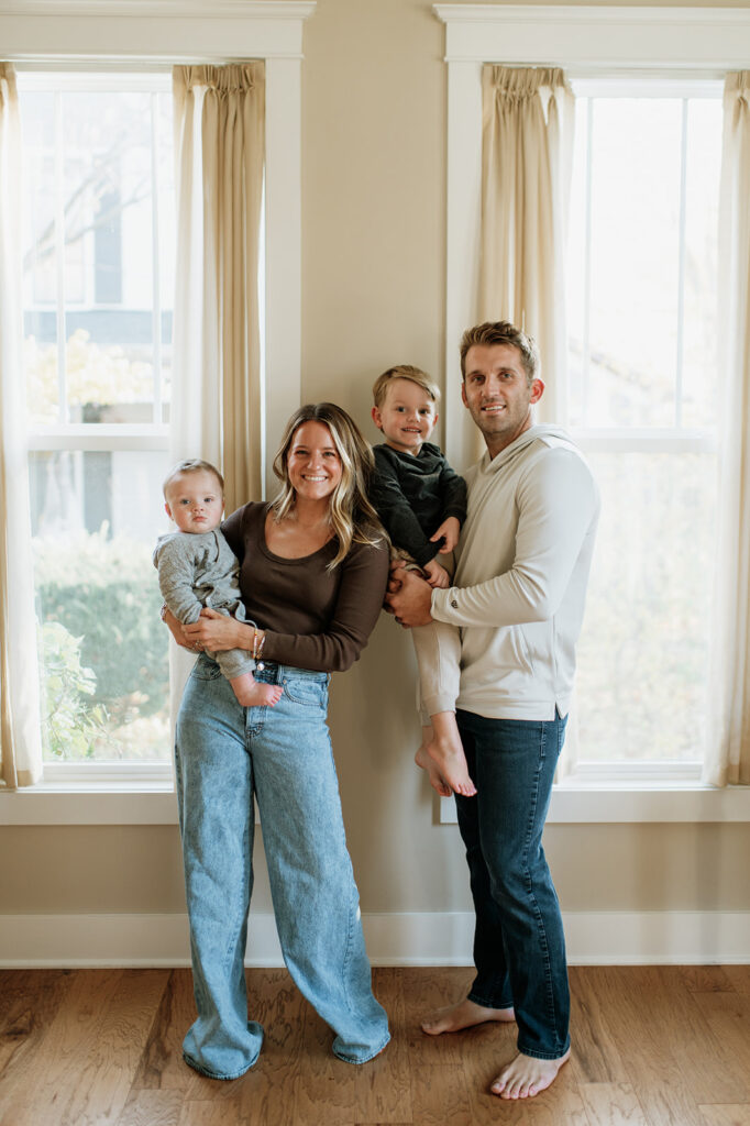 Family of four posing in their home for their at-home Northern Indiana family photos