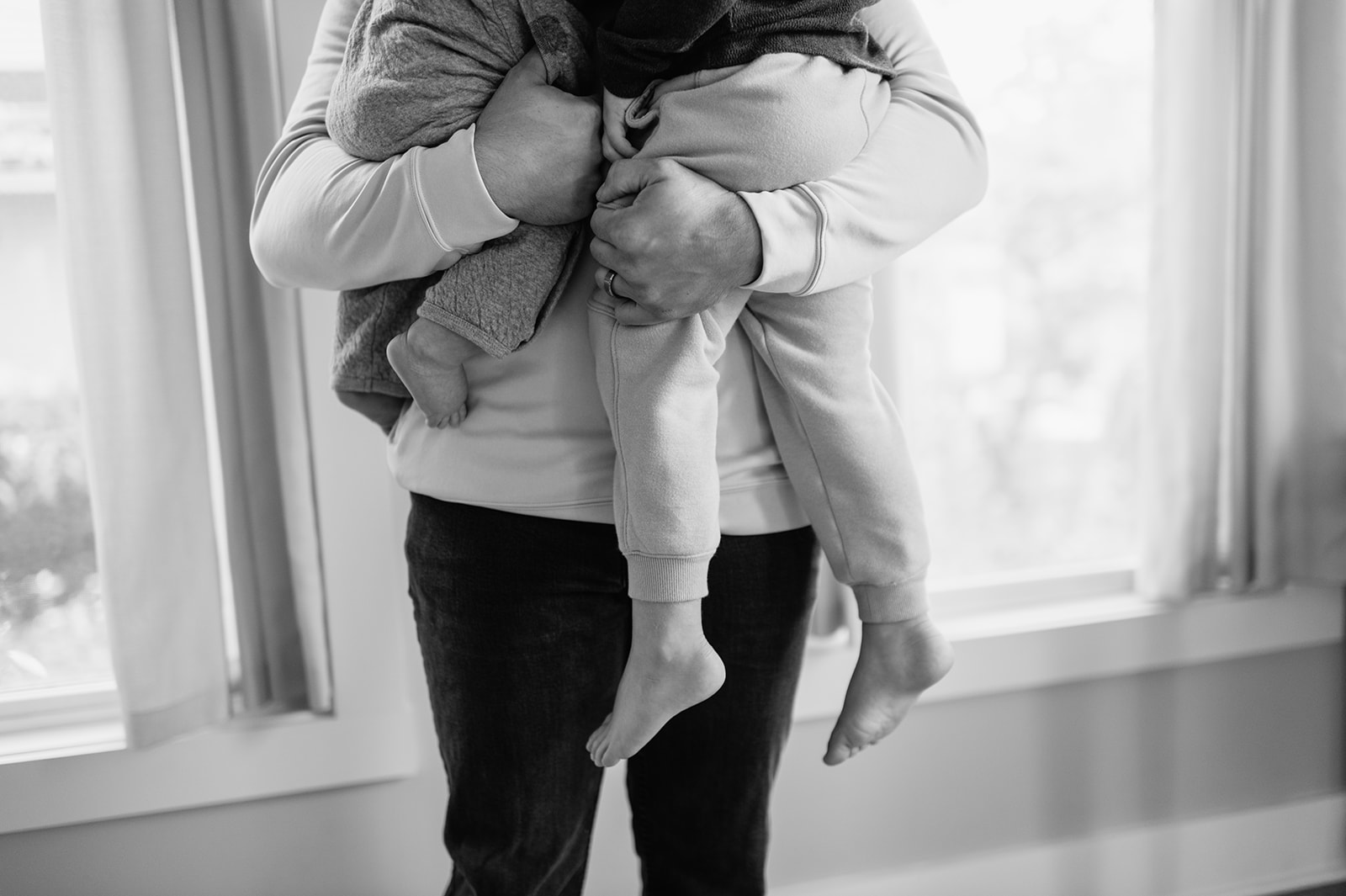 Black and white photo of a dad holding his two sons