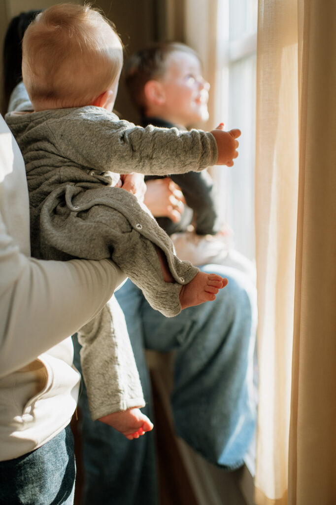 Family of four looking out their window for their at-home Northern Indiana family photos