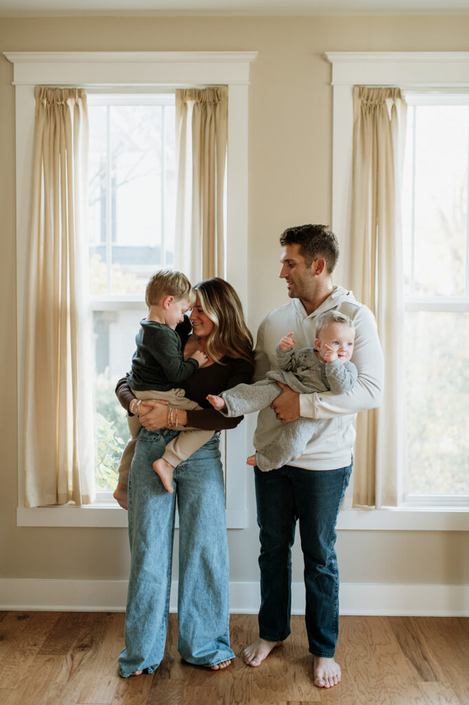 Family of four posing in their home for their at-home Northern Indiana family photos