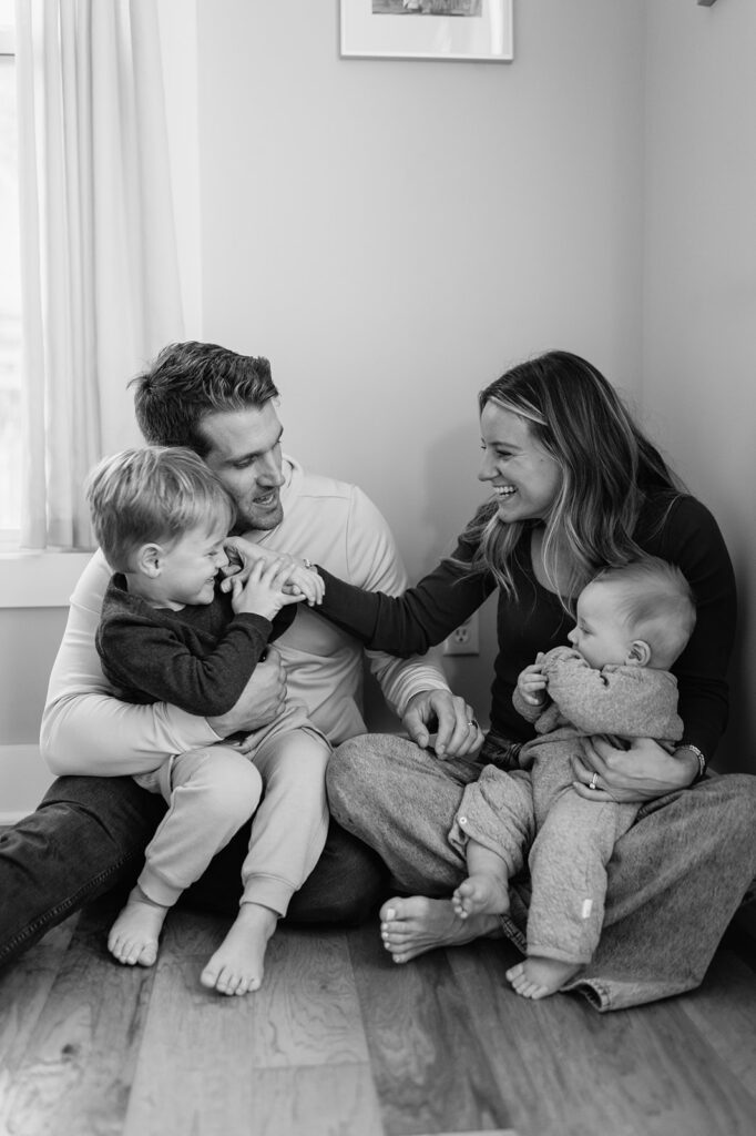 Black and white photo of a family of four sitting on their floor