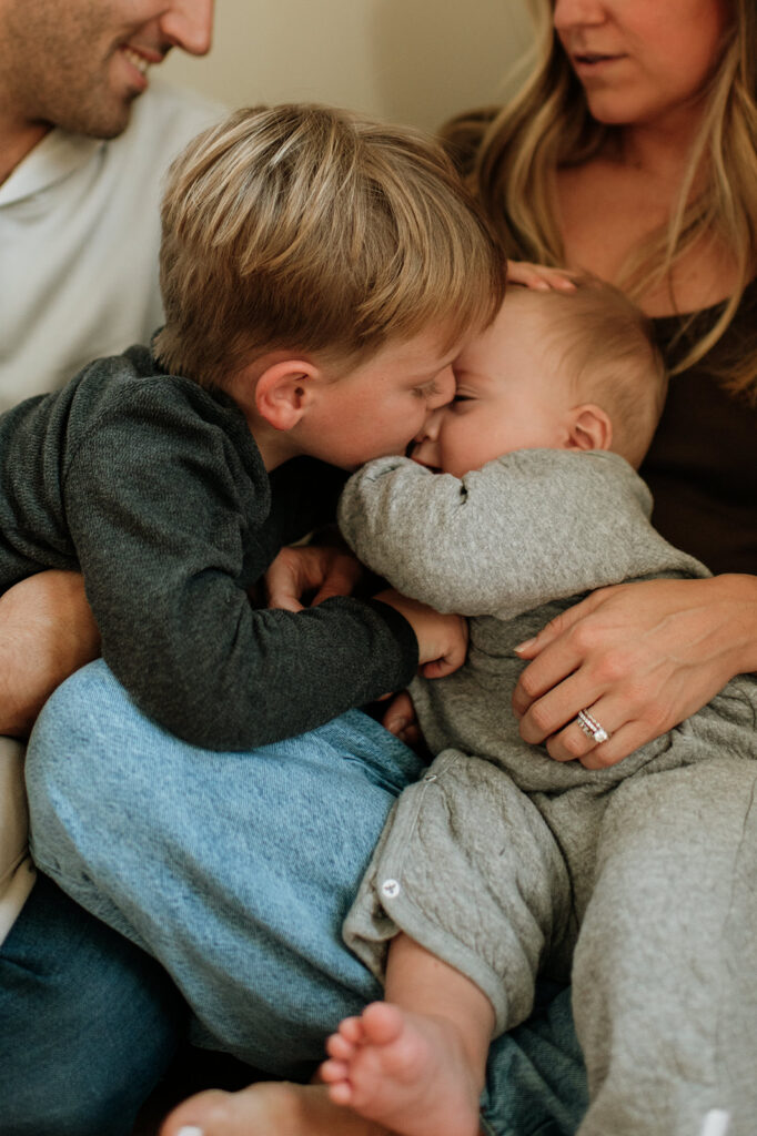 Big bother kissing his baby brother