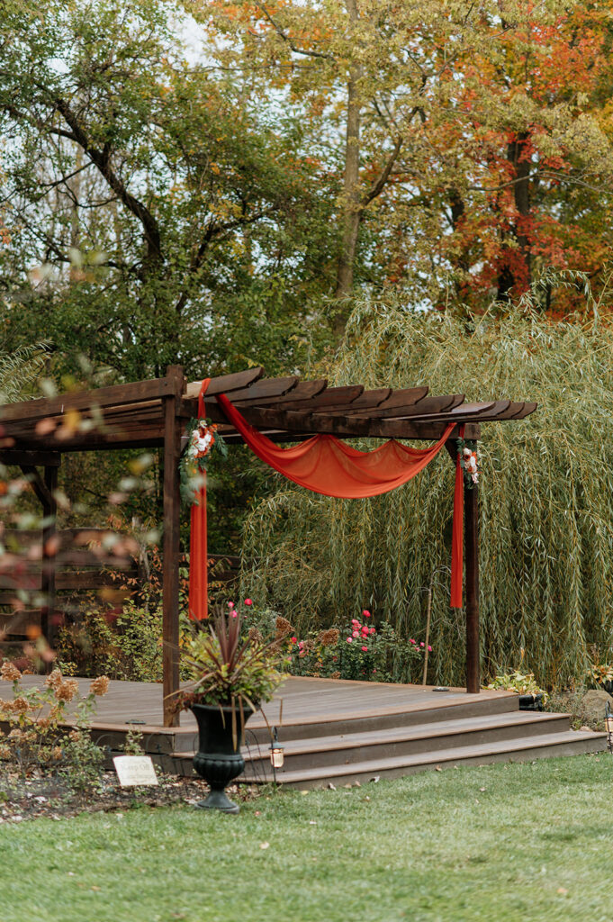 An outdoor fall Willow Acres wedding ceremony on the Pergola