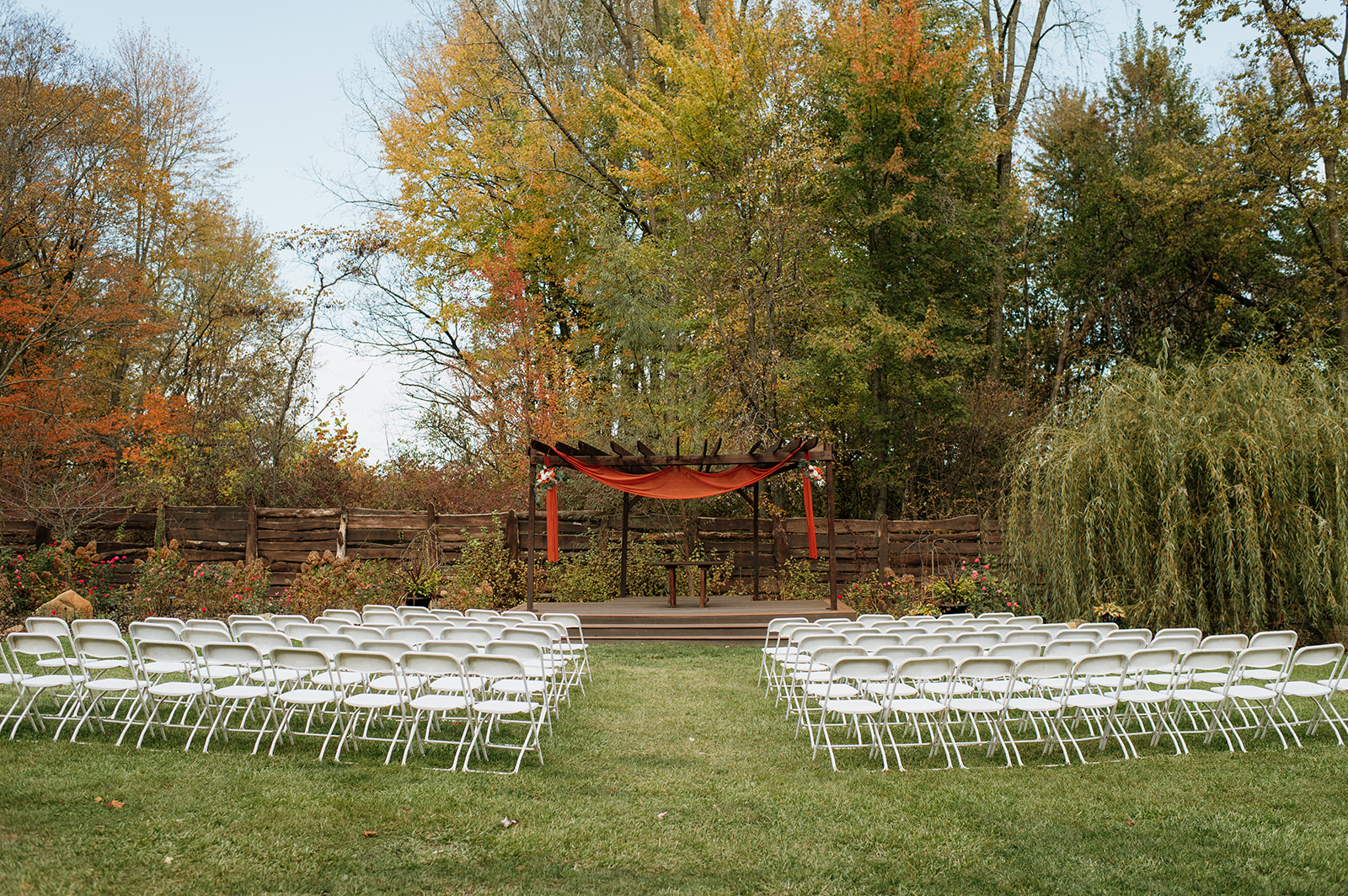 An outdoor fall Willow Acres wedding ceremony on the Pergola