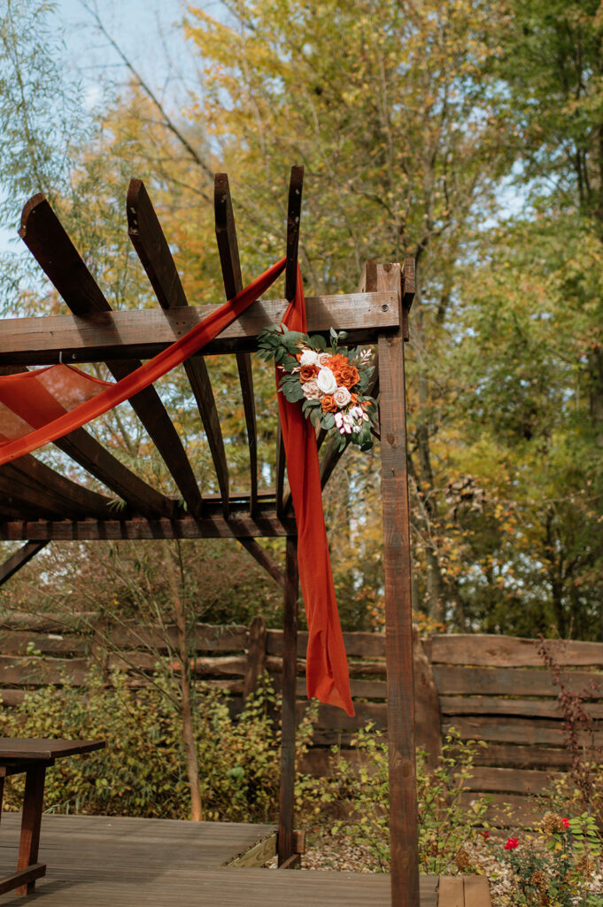 An outdoor fall Willow Acres wedding ceremony on the Pergola