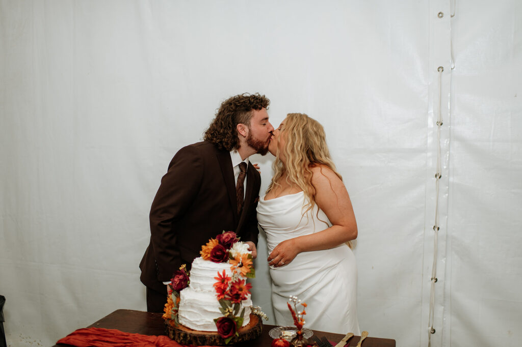 Bride and groom kissing during cake cutting