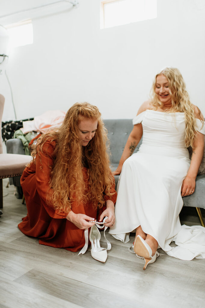 Bride getting her shoes put on