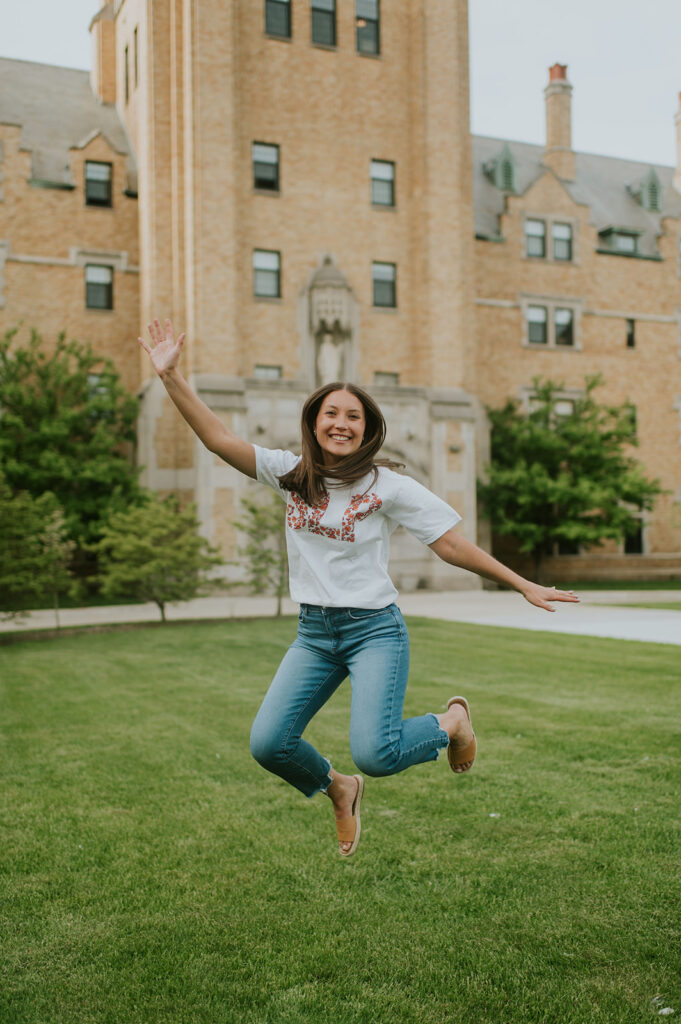 Girl jumping in the air during her graduation shoot 