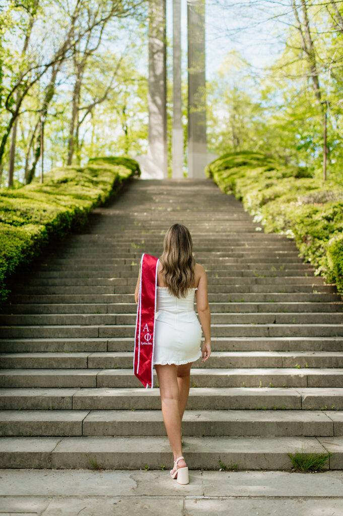 Graduate walking up a set of stairs