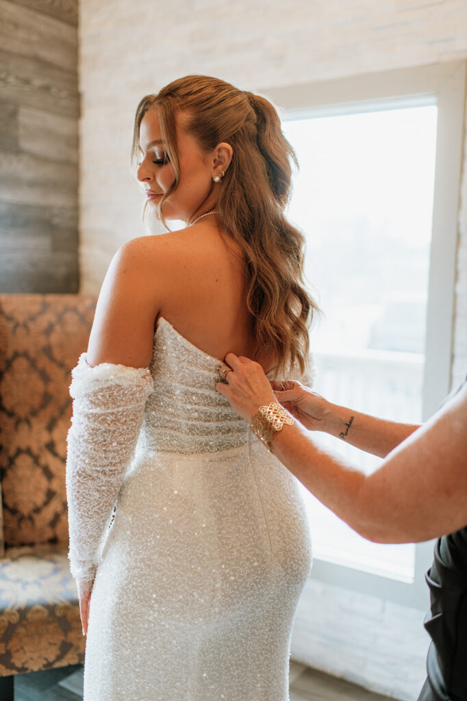 Bride getting her dress zipped up