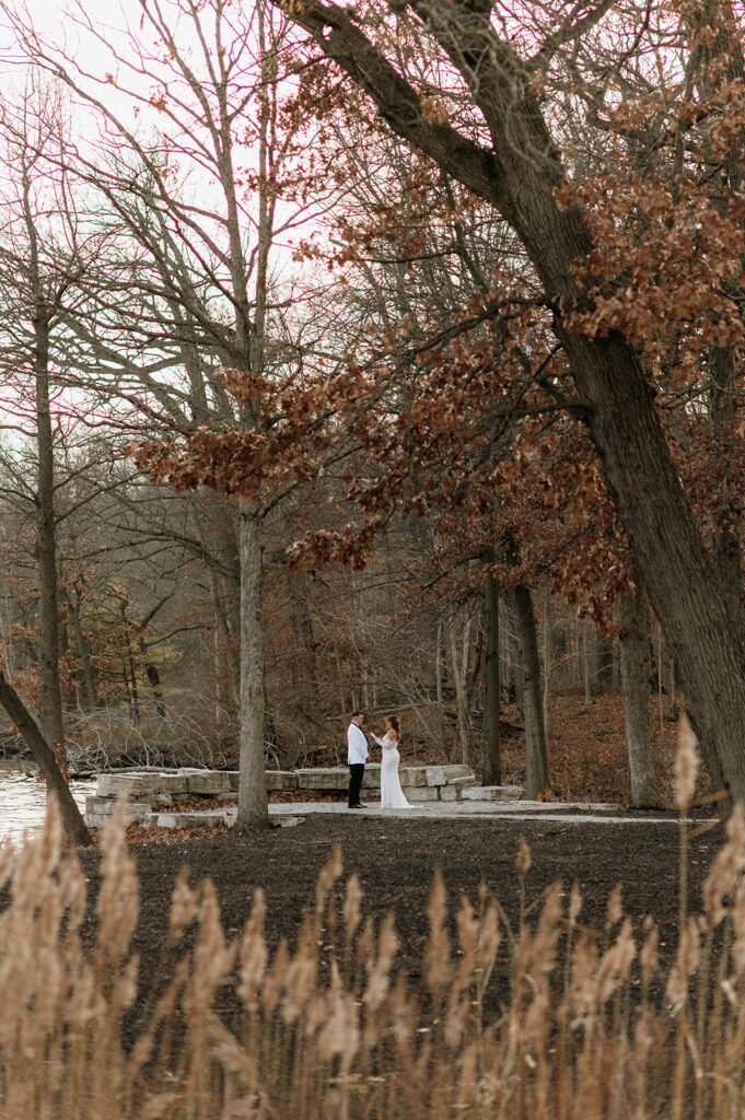 Bride and grooms exchanging vows during their winter wedding at The Allure on The Lake