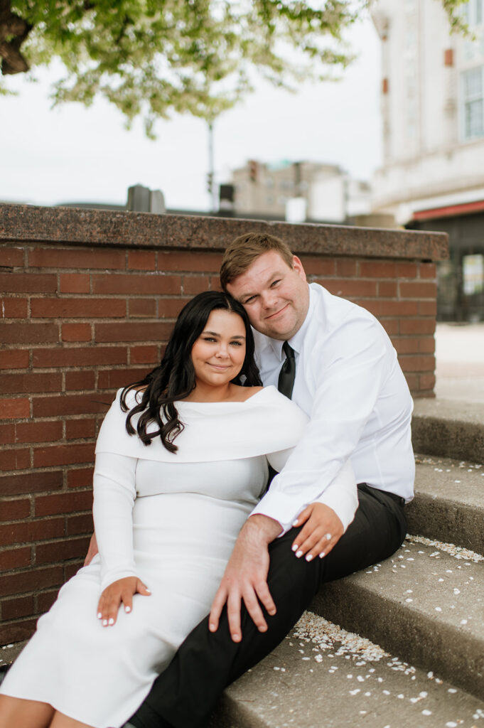 Couple sitting on stairs for their outdoor South Bend engagement photos