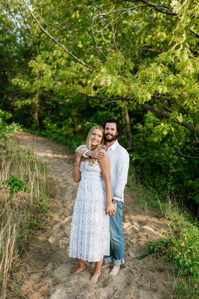 Couple posing along a beach trail for their summer engagement photos in Indiana