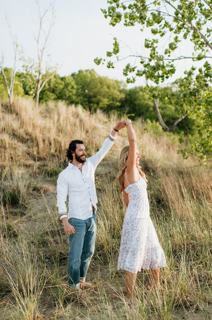 Couple being playful in the beach grass for their Indiana Dunes State Park engagement photos