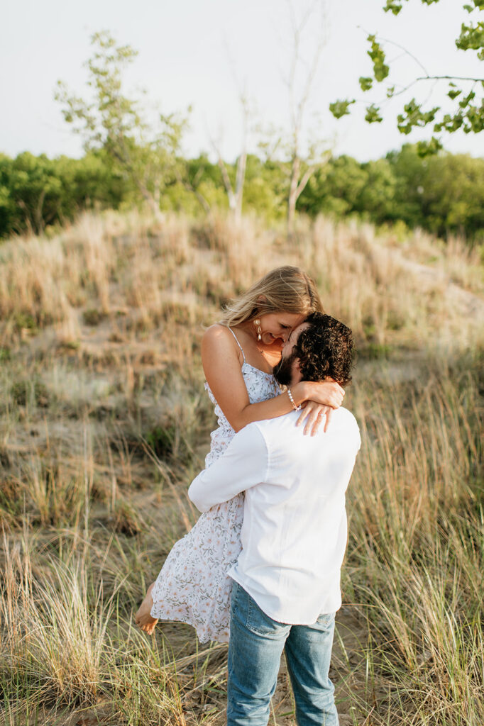 Couple being playful in the beach grass for their Indiana Dunes State Park engagement photos