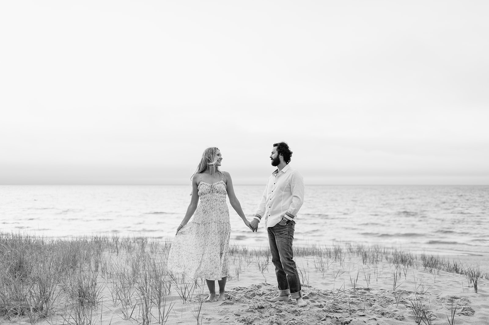 Couple holding hands on the beach for their Indiana Dunes State Park engagement photos