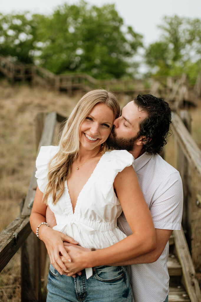 Couple posing on a boardwalk staircase for their Indiana Dunes National Park engagement photos
