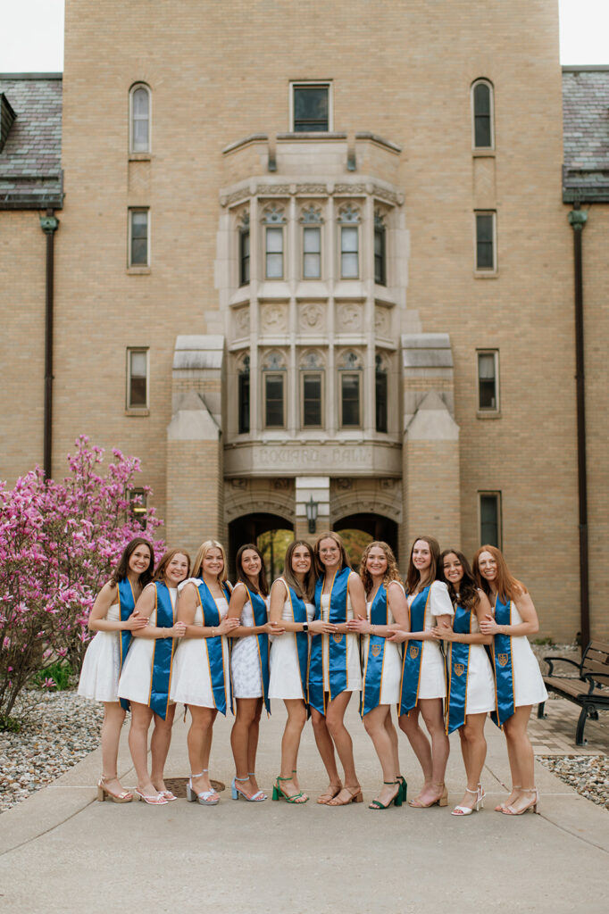 11 graduates posing together for photos