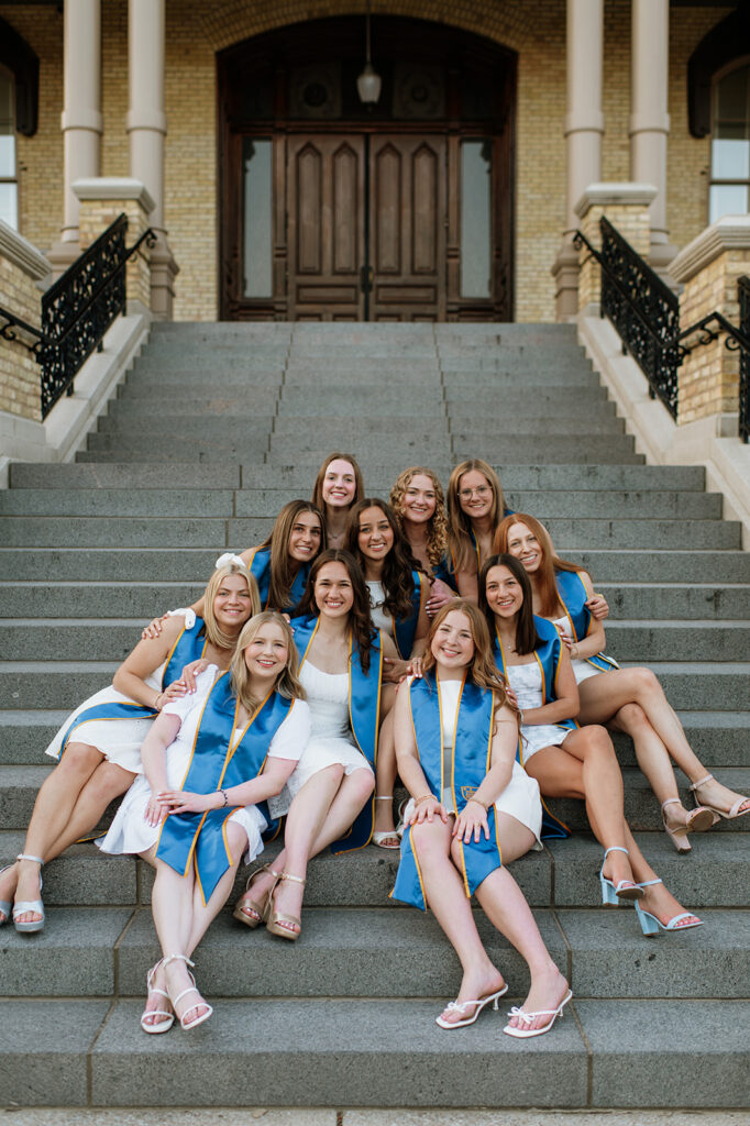 11 Notre Dame University grad students posing for their graduation photos on the Main Building Steps