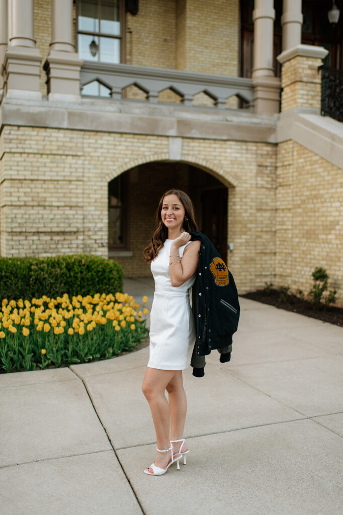Notre Dame graduate posing for photos with her Baraka Bouts jacket