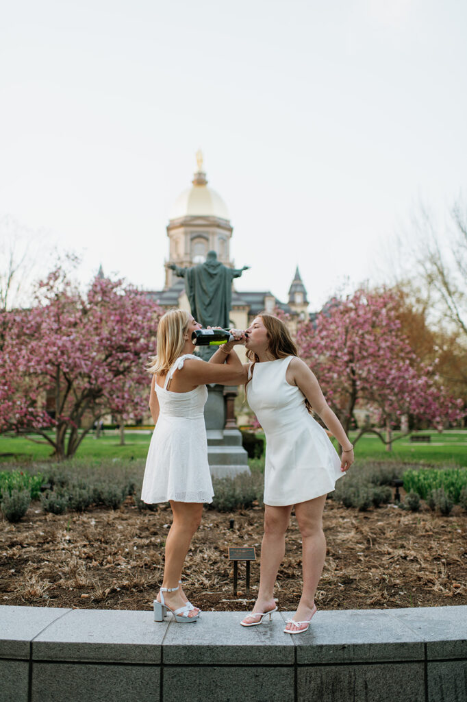 Girl drinking champagne during their grad shoot